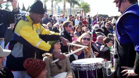 A WCU drummer gives his drumsticks to a Rose Parade-goer and invites him to play the drum during a parade break.